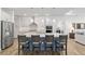 Kitchen island with seating, modern cabinetry, pendant lighting, and views into the living room at 9764 Sw 81St Ln, Ocala, FL 34481