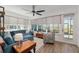 Bright living room with hardwood floors, large windows, and a comfortable blue sectional sofa at 9764 Sw 81St Ln, Ocala, FL 34481