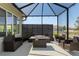 Spacious screened-in patio with modern wicker furniture and a stylish fire pit table at 9764 Sw 81St Ln, Ocala, FL 34481