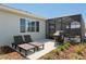 A cozy patio features lounge chairs and a grill, next to a screened-in lanai for outdoor enjoyment at 9764 Sw 81St Ln, Ocala, FL 34481