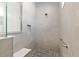 Contemporary walk-in shower with gray tiling, a built-in bench, and mosaic tile flooring at 9764 Sw 81St Ln, Ocala, FL 34481
