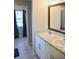 Bathroom with a double vanity featuring modern sinks, a large mirror, and stylish wood trim at 10 Banyan Track Way, Ocala, FL 34472