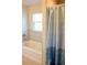 Clean bathroom showcasing a bathtub, tiled walls, and a blue patterned shower curtain at 10 Banyan Track Way, Ocala, FL 34472