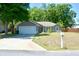 Inviting single-story home boasts an attached garage, mature trees, and a pristine lawn at 10 Banyan Track Way, Ocala, FL 34472