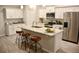Bright kitchen with white cabinets, stainless steel appliances, and an island with seating and a granite countertop at 10 Banyan Track Way, Ocala, FL 34472
