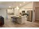 Bright kitchen features white cabinetry, stainless steel appliances, and a large island with bar seating at 10 Banyan Track Way, Ocala, FL 34472