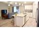 Modern kitchen island with marble countertop and stainless steel dishwasher seamlessly flows into the living room at 10 Banyan Track Way, Ocala, FL 34472