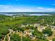 Beautiful aerial view of the home surrounded by lush greenery, with a serene lake in the distance at 10605 Se 146Th Ln, Summerfield, FL 34491