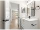 Modern bathroom featuring a white vanity with black fixtures, a mirror, and luxury vinyl plank flooring at 10605 Se 146Th Ln, Summerfield, FL 34491