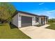Charming home with a gray garage door, covered entry and manicured lawn on a sunny day at 10605 Se 146Th Ln, Summerfield, FL 34491