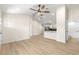 Bright open floor plan featuring wood-look floors, a modern ceiling fan, and neutral wall color at 10605 Se 146Th Ln, Summerfield, FL 34491