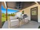 Inviting covered patio featuring a ceiling fan, comfortable seating, grill and outdoor view at 10605 Se 146Th Ln, Summerfield, FL 34491