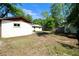 Spacious backyard view showing the home's exterior, lush greenery, and a shed at 1145 Se 32Nd Ave, Ocala, FL 34471