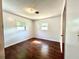 Simple bedroom featuring hardwood floors, neutral white walls and two windows at 1145 Se 32Nd Ave, Ocala, FL 34471