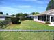 Large backyard with green lawn, chain link fence, and privacy bushes at 11536 Sw 138Th Ln, Dunnellon, FL 34432