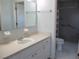 Bathroom with a vanity, a toilet and a walk-in shower behind a flowered shower curtain at 11536 Sw 138Th Ln, Dunnellon, FL 34432