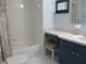 Bathroom features a tub and shower combination plus vanity with blue cabinetry at 11536 Sw 138Th Ln, Dunnellon, FL 34432