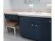 Bathroom vanity with blue cabinetry, white countertop, stool and sink at 11536 Sw 138Th Ln, Dunnellon, FL 34432