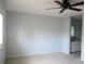 Neutral bedroom with ceiling fan, neutral colored walls, and view of the attached bathroom at 11536 Sw 138Th Ln, Dunnellon, FL 34432