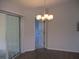 Dining room with modern chandelier, view of glass doors to the patio, and view to hallway at 11536 Sw 138Th Ln, Dunnellon, FL 34432