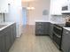 Modern kitchen featuring sleek gray cabinets, stainless steel appliances, and light countertops at 11536 Sw 138Th Ln, Dunnellon, FL 34432