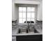 Kitchen featuring a stainless steel sink, and gray countertops, complemented by sleek, modern cabinetry at 11536 Sw 138Th Ln, Dunnellon, FL 34432