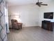 Relaxing living room with high ceilings, ceiling fan, comfortable seating, and modern entertainment center at 11536 Sw 138Th Ln, Dunnellon, FL 34432