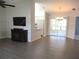 Open living room with modern flooring, television, sliding glass doors, and adjacent kitchen at 11536 Sw 138Th Ln, Dunnellon, FL 34432