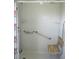 Walk-in shower featuring grab bars and a fold-down wooden bench at 11536 Sw 138Th Ln, Dunnellon, FL 34432