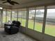 Bright sunroom with a comfortable recliner and expansive windows overlooking the backyard at 11536 Sw 138Th Ln, Dunnellon, FL 34432
