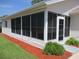 Exterior view of the enclosed sunroom with many windows and an entry door at 11536 Sw 138Th Ln, Dunnellon, FL 34432