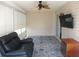 Enclosed sunroom with a ceiling fan, mounted television, and comfortable seating at 11536 Sw 138Th Ln, Dunnellon, FL 34432