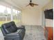 Inviting sunroom featuring neutral colors, a ceiling fan, and a comfortable leather recliner at 11536 Sw 138Th Ln, Dunnellon, FL 34432