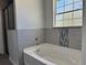 Bright bathroom featuring a soaking tub with tile surround and natural light from the window at 1233 Sw Winding Hills Rd, Dunnellon, FL 34431