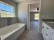 Well-lit bathroom featuring a tub, tile accents, and vanity, creating a serene atmosphere at 1233 Sw Winding Hills Rd, Dunnellon, FL 34431