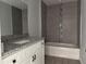 Bathroom showcasing granite counters, a tub with tiled walls, and modern fixtures at 1233 Sw Winding Hills Rd, Dunnellon, FL 34431