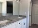 Bathroom vanity featuring double sinks, granite countertops, white cabinets, and modern fixtures at 1233 Sw Winding Hills Rd, Dunnellon, FL 34431