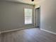 A cozy bedroom featuring neutral walls, white trim, vinyl flooring, and natural light at 1233 Sw Winding Hills Rd, Dunnellon, FL 34431