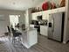 Bright kitchen features white cabinetry, stainless steel appliances, and a granite-topped island with bar seating at 13356 Sw 66Th St, Ocala, FL 34481
