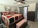 Comfortable main bedroom with a ceiling fan, a patterned quilt, and a barn door leading to the bathroom at 13356 Sw 66Th St, Ocala, FL 34481