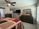 Comfortable main bedroom with ceiling fan and plenty of dresser space, including a wall-mounted television at 13356 Sw 66Th St, Ocala, FL 34481
