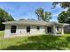 Green backyard featuring a home exterior with a covered patio and lush lawn at 13506 Sw 114Th Ln, Dunnellon, FL 34432