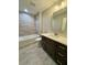 Bright bathroom featuring a modern vanity, tiled bathtub, and neutral color palette at 13506 Sw 114Th Ln, Dunnellon, FL 34432