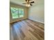 Serene bedroom with a ceiling fan, large window, and wood-look flooring at 13506 Sw 114Th Ln, Dunnellon, FL 34432