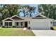 Charming home featuring a two-car garage, landscaped yard, and stone accents at 13506 Sw 114Th Ln, Dunnellon, FL 34432