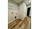 Spacious laundry room with wood-look flooring, wire shelving, and utility connections at 13506 Sw 114Th Ln, Dunnellon, FL 34432
