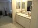 Bathroom features a vanity with white cabinets, mirror, and an open doorway leading into the living area at 13675 Sw 111Th Ave, Dunnellon, FL 34432