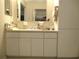 Bathroom features a vanity with white cabinets and a framed mirror with a view into the walk-in closet at 13675 Sw 111Th Ave, Dunnellon, FL 34432