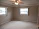 Neutral bedroom with carpet, two windows, and ceiling fan offering natural light and comfortable living space at 13675 Sw 111Th Ave, Dunnellon, FL 34432