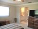 Bright bedroom features ensuite bathroom, warm neutral color palette and tile flooring at 13675 Sw 111Th Ave, Dunnellon, FL 34432
